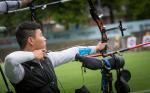 Korean male archer pulls back on his bow string aiming for a target