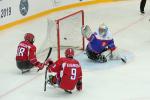 Two Russian Para ice hockey players in front the Slovakian goaltender