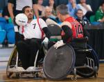 Swiss man in wheelchair rugby protects the ball against his opponent