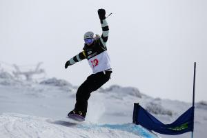 A picture of a woman jumping with a snowboard