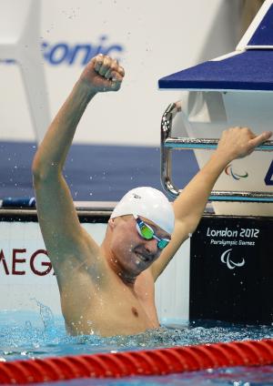 A picture of a man holding his hand up with clenched fist in the pool