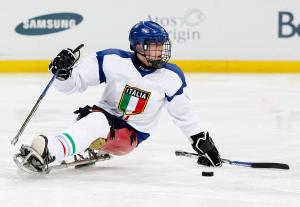 A picture of a man in a sledge practising Ice Sledge Hockey.