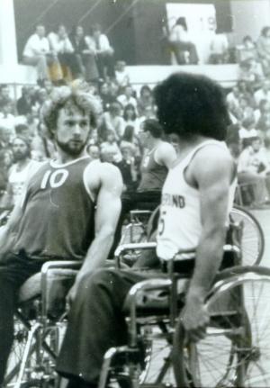 A picture of 2 men in a wheelchair playing wheelchair basketball