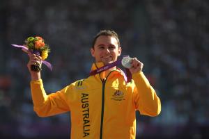 A picture of a man on a podium with a medal around his neck