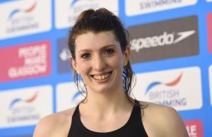 A swimmer smiles having won gold and set a new world record