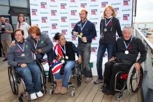 A picture of a 3 person in a wheelchair after receiving their medals