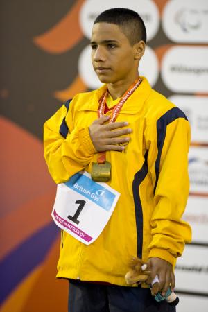 Man in yellow training suit on a podium.