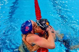 Two swimmers hugging after a race