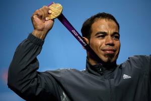 A picture of a man on a podium with a medal aorund his neck