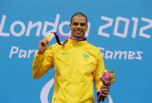 Swimmer holding his medal on the podium