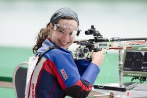 Woman in shooting range, looking back over her shoulder, smiling