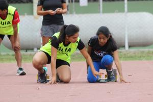 vision impaired runner competing on the track with her guide
