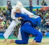 Two judo athletes fighting on the ground.